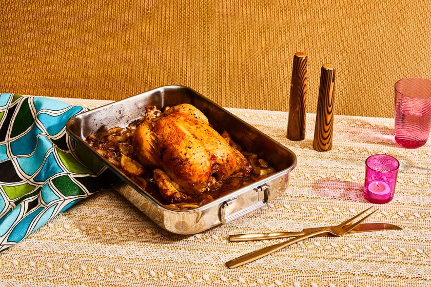 Whole roasted chicken in silver pan on table with lace tablecloth