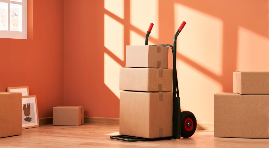 moving boxes on a handcart in and empty orange room