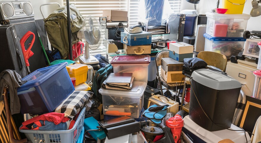 Hoarder room packed with boxes, electronics, business equipment, household objects and miscellaneous junk.