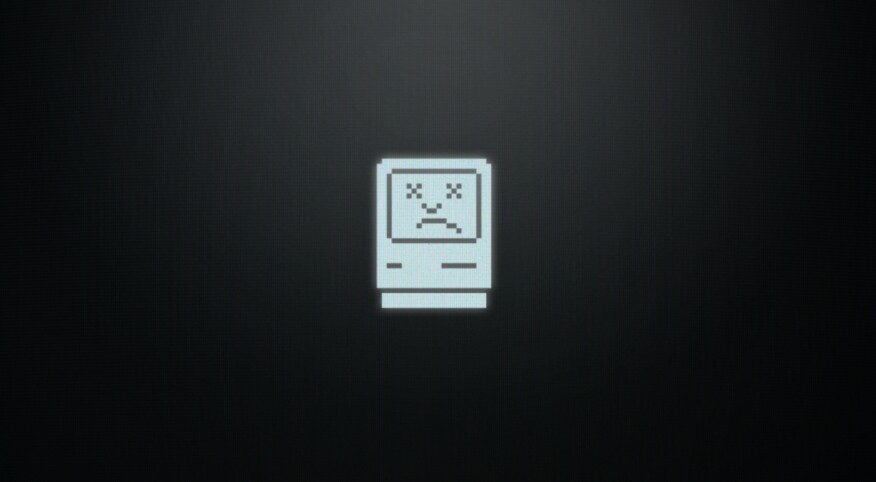 Computer screen depicting the vintage Macintosh operating system sad face icon