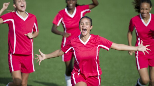 Female soccer players celebrate a goal