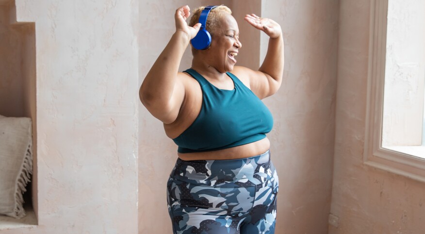 Older Black woman dancing with headphones on