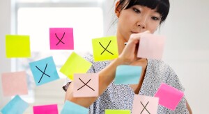 Woman crossing off colorful post-its