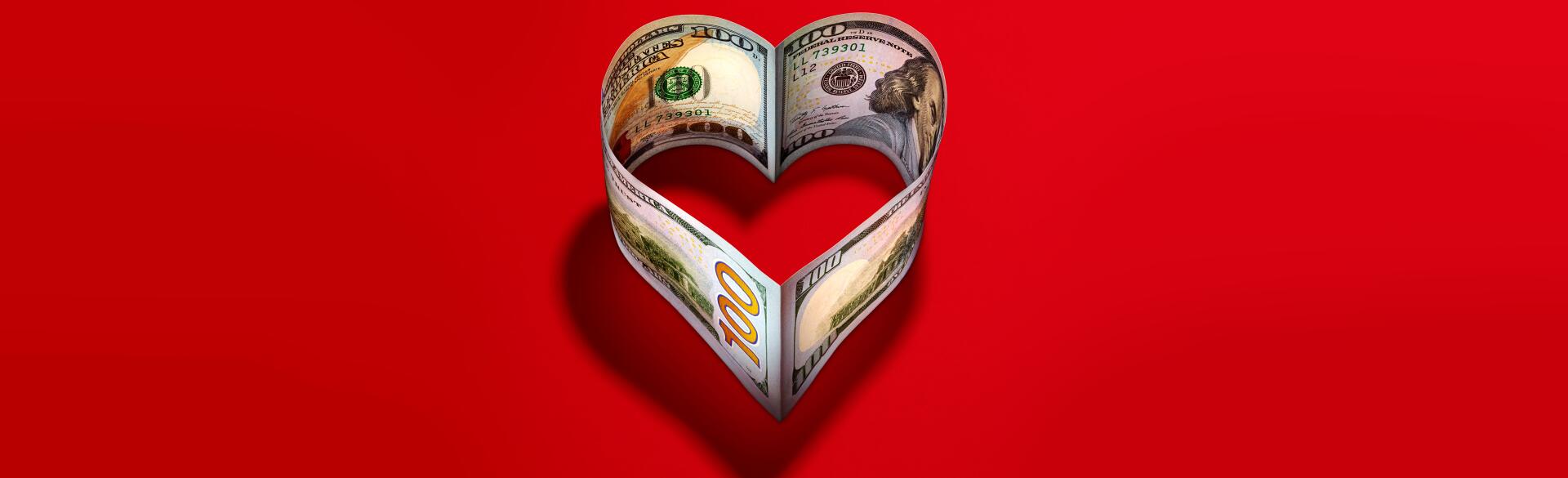 heart made of 100 dollar bills on a red background
