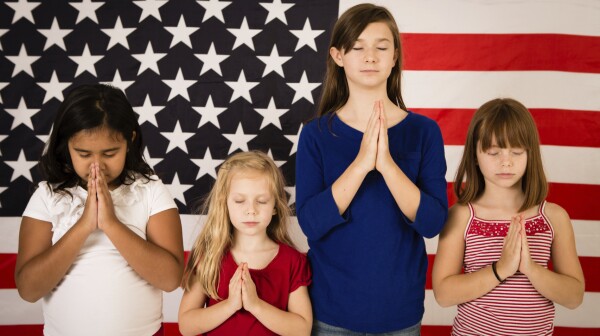 Multi-Ethnic Girls Praying in Front of American Flag
