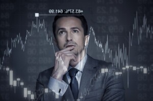 Man in suit and tie contemplating stock market charts