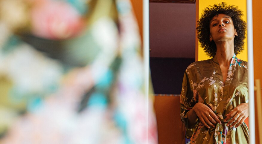 Woman staring in the mirror wearing a silk robe