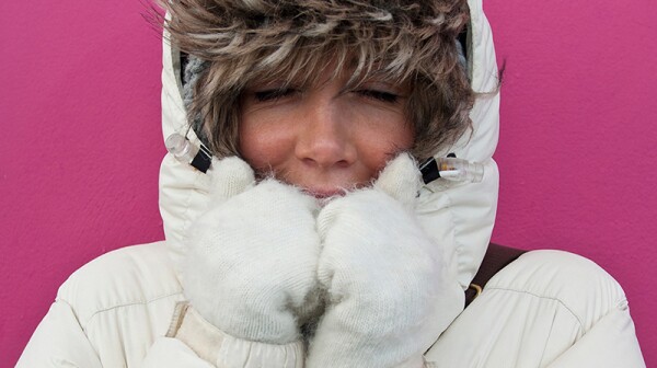 An up-close view of a woman wearing a puffer jacket with the hood up