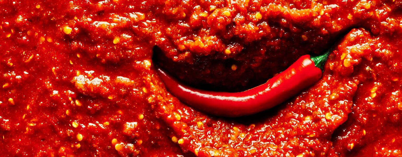 An image of a chili pepper in hot sauce.