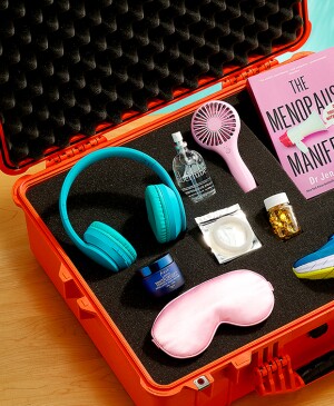 Various items including lube, sneakers, a fan and sleep mask in a safe foam case sitting on a table at home