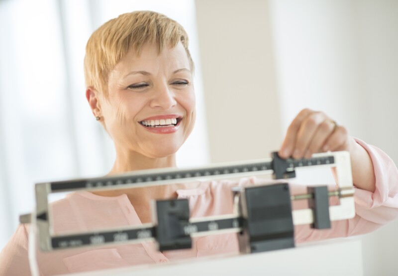 Happy Woman Adjusting Balance Weight Scale
