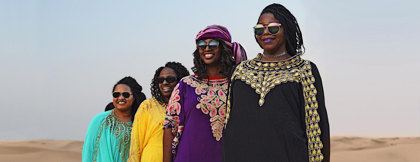 A group of four women stand in the UAE desert near Abu Dhabi.