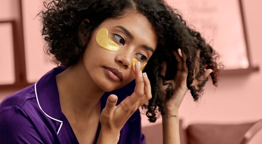 Woman in pajamas putting on beauty skin patches