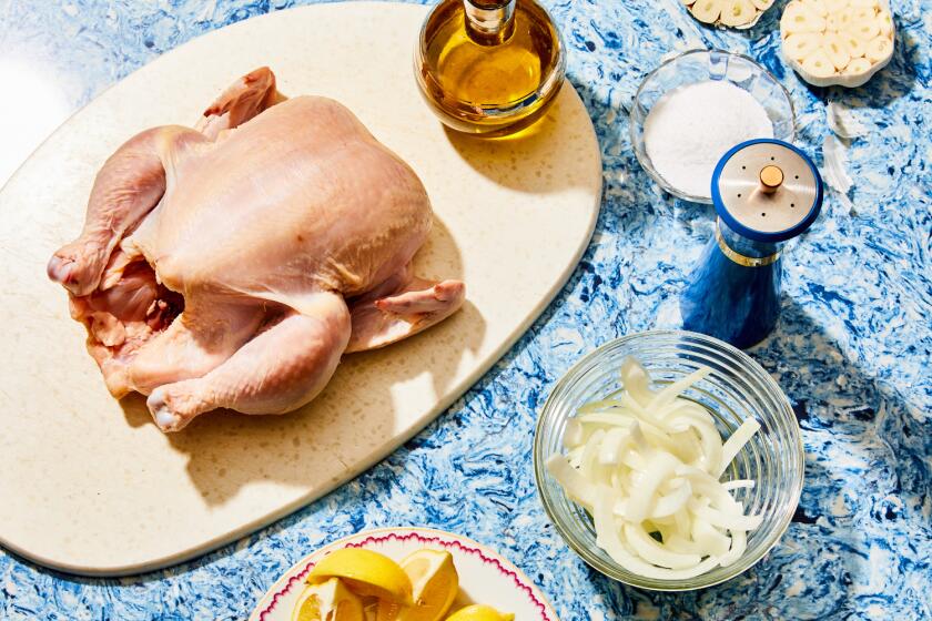 Whole raw chicken with lemons, onions, olive oil, salt and pepper