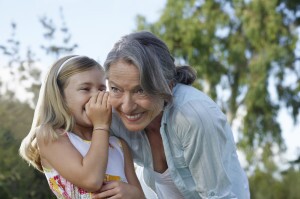 Girl Whispering In Grandmother's Ear