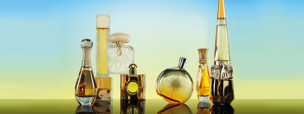 Seven Perfume bottles on a gradient blue to yellow background