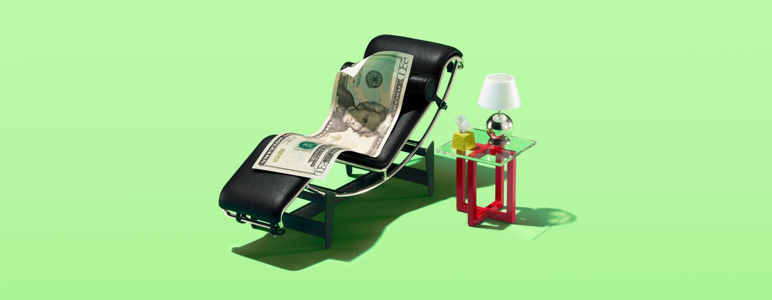 A 20 dollar bill sitting in a tiny therapist chair with a lamp and tissues