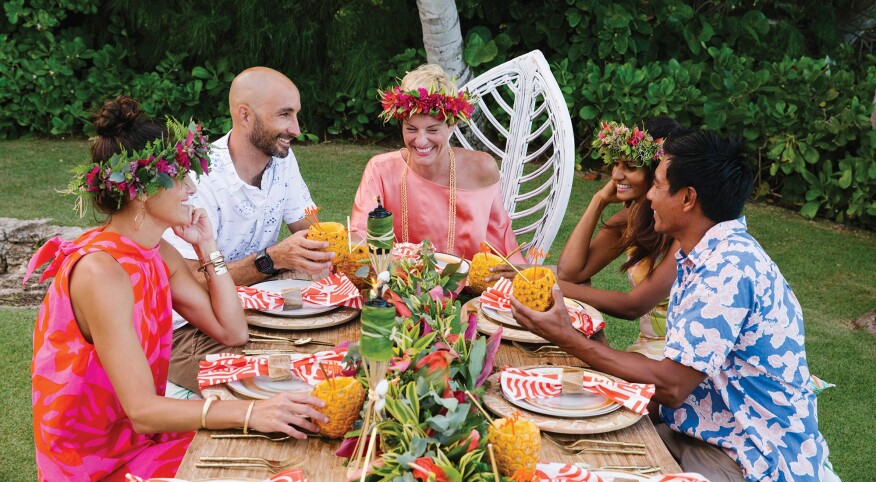 Five adults at Hawaiian-themed birthday celebration