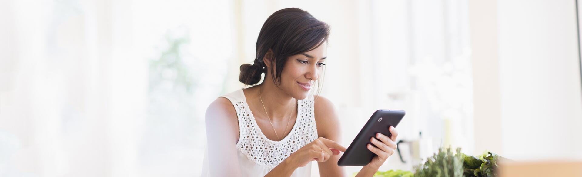 Hispanic woman cooking with digital tablet