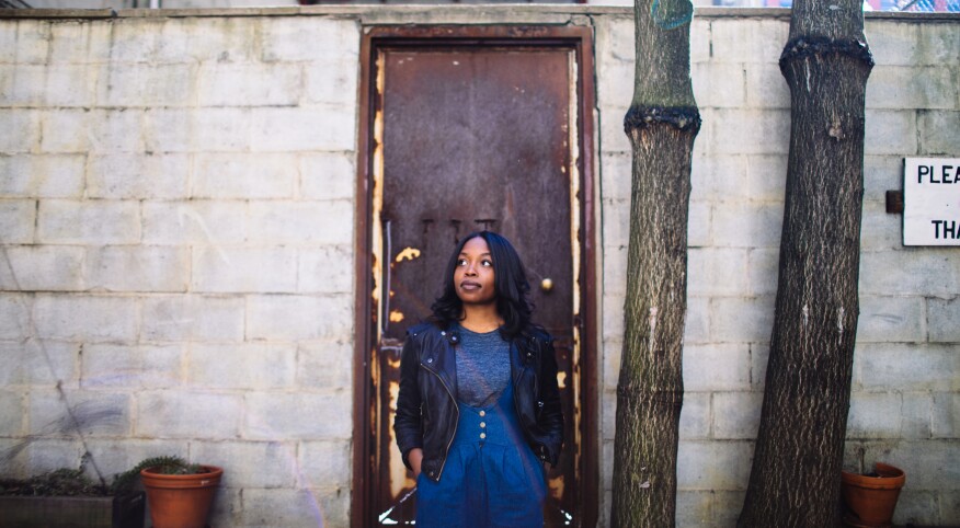 woman standing alone in front of a doorway