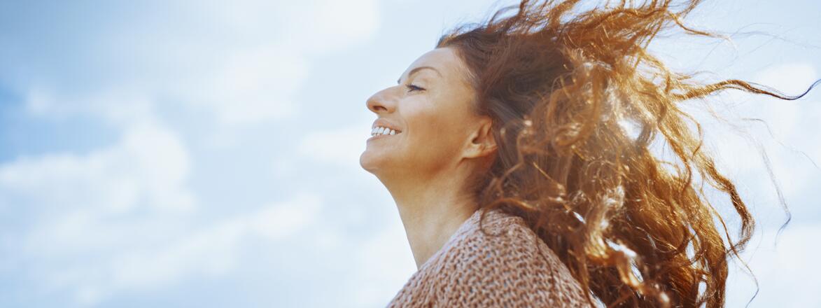 Woman outside enjoying the wind in her hair