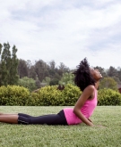 Woman doing yoga outside to help with perimenopause pain.