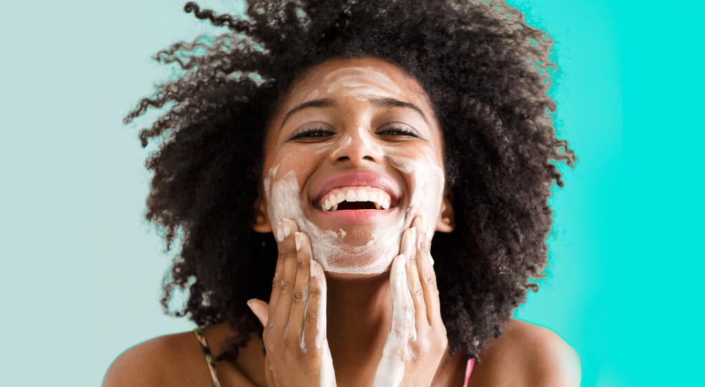 A woman washing her face to combat signs of aging.