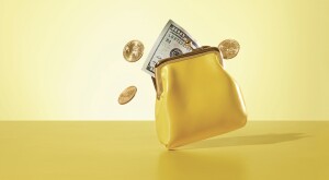 yellow coin purse with money and coins coming out of it