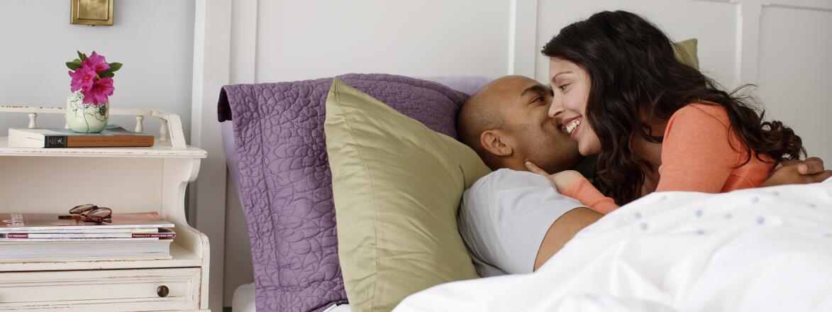couple in bed whispering to each other