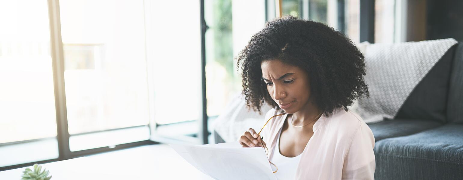 Woman sitting at table looking over finances