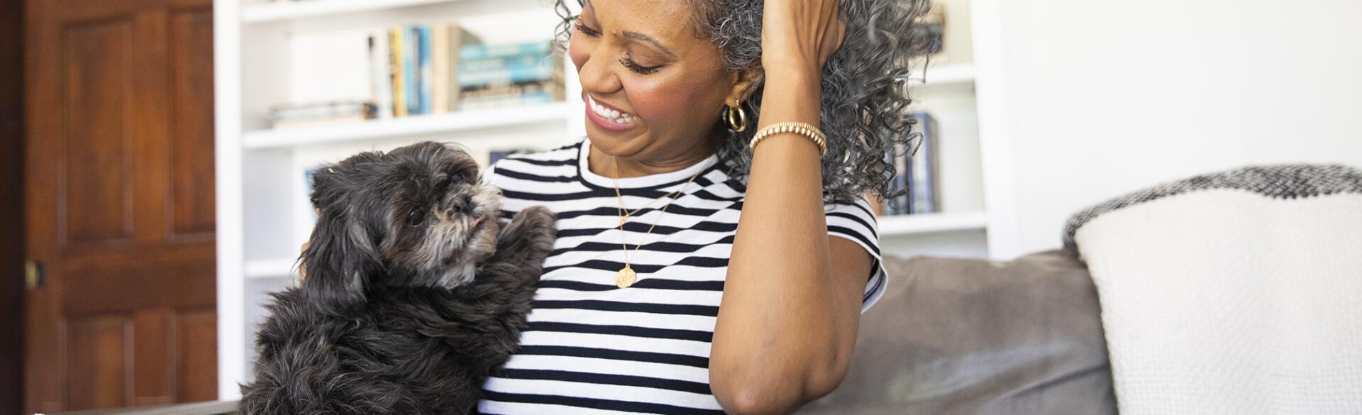 Black Woman Cuddles with her dog at home