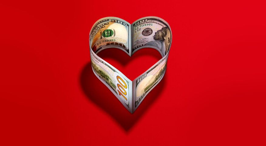 heart made of 100 dollar bills on a red background