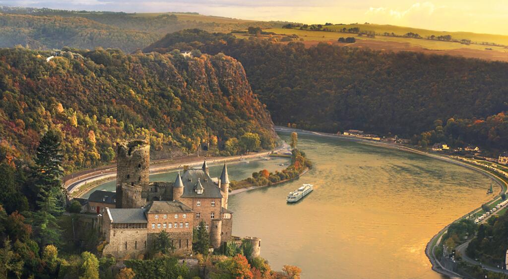 a landscape of grass cliffs, a castle and a cruise in the water