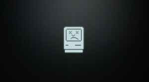 Computer screen depicting the vintage Macintosh operating system sad face icon