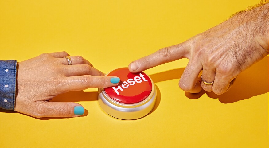 Female and male hand pressing a reset button