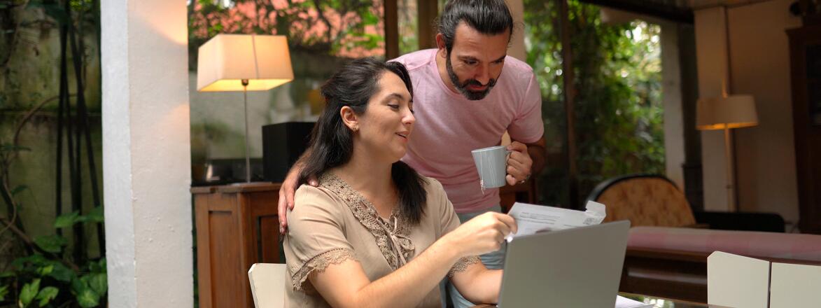 Woman and adult son looking over documents at home