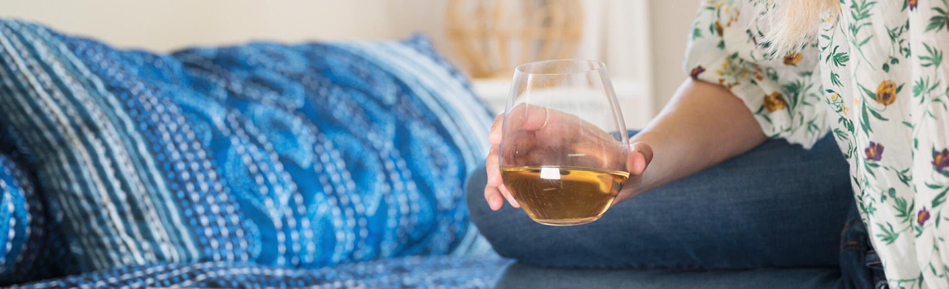 Woman With Glass Of Wine Using Tablet To Chat