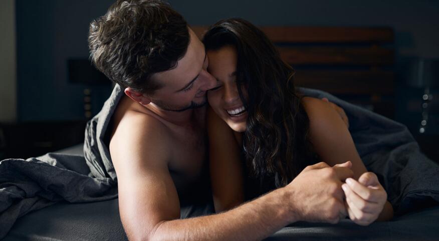 Couple in bed underneath the sheets