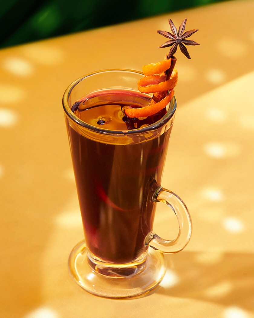 Holiday mulled wine garnished with star anise on a yellow background