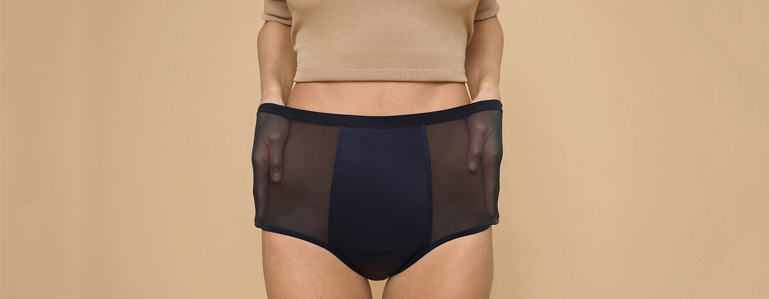 A woman stretches out the sides of her Thinx hi-waist panties, which can double for bladder leakage.