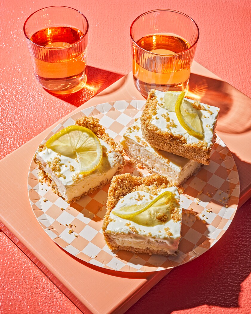 Overhead photo of frozen lemon dessert bars on bright orange background