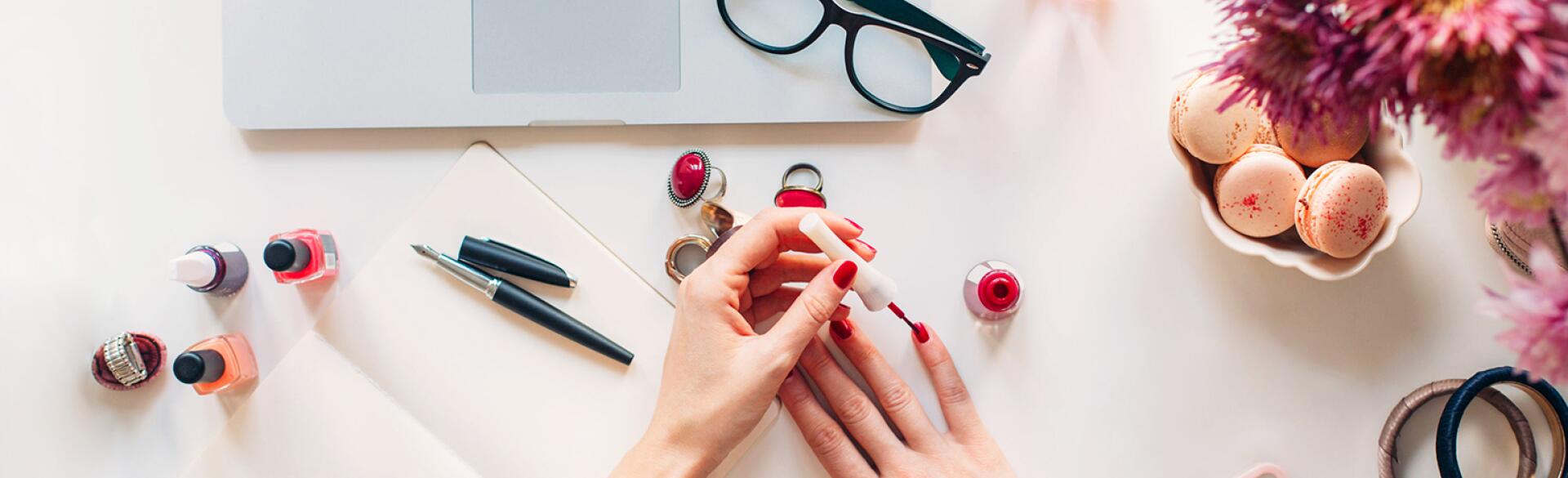 women painting her nails near her computer screen