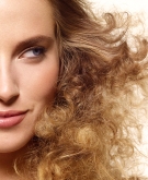 Woman with big frizzy blonde hair looking to the side