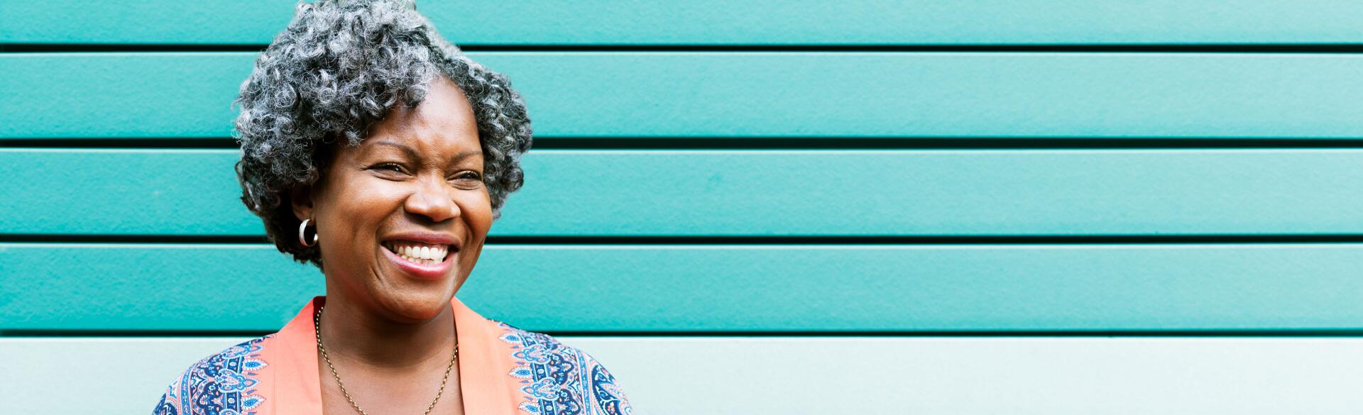 Woman smiling in front of a turquoise wall