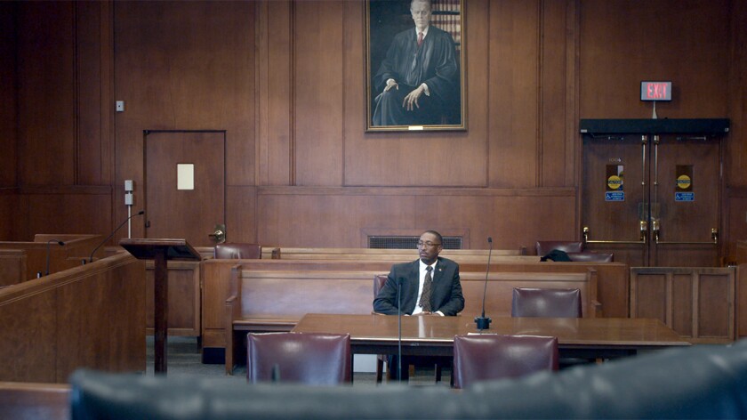 Sean Ellis sits in a courtroom in a still from the documentary Trial 4.