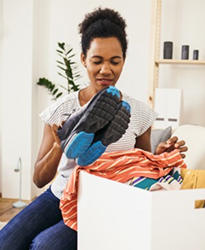Black woman in her 40s clearing her space of clutter