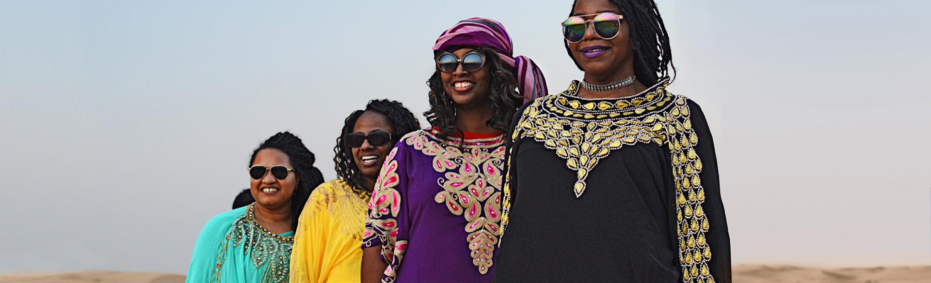 A group of four women stand in the UAE desert near Abu Dhabi.