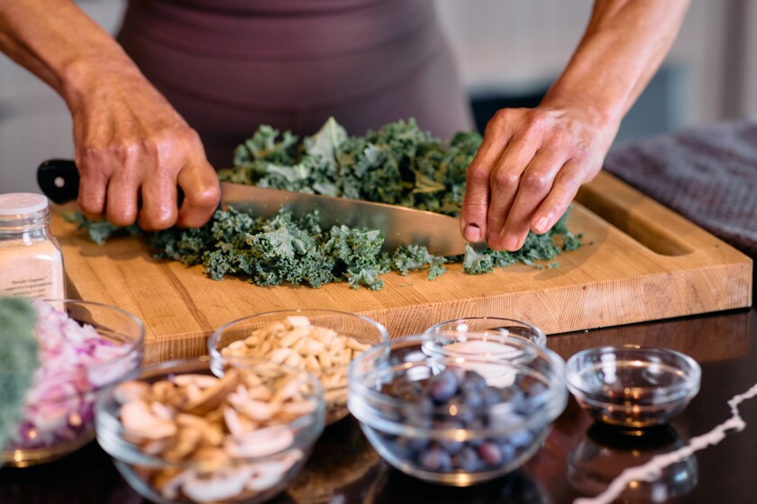 Chef Babette preparing a leafy green meal with portioned ingredients