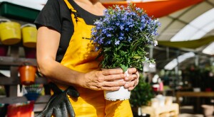Woman in yellow overalls working in a garden shop.