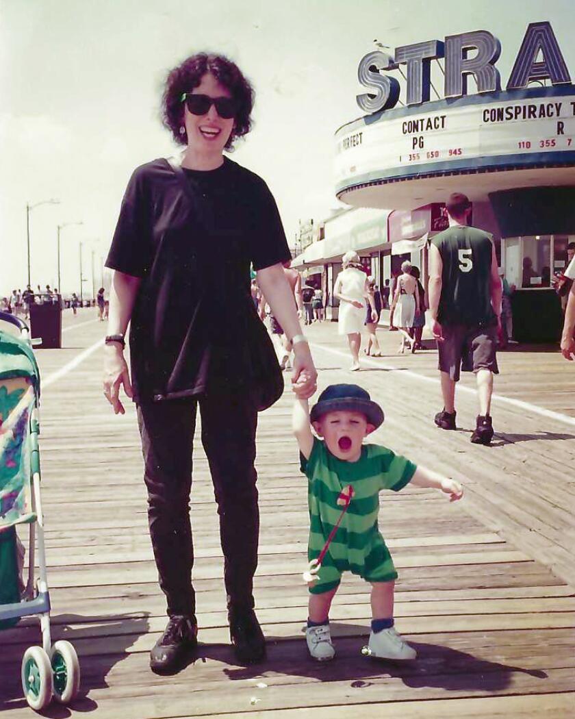 Caroline Leavitt holding hands with her son on the boardwalk